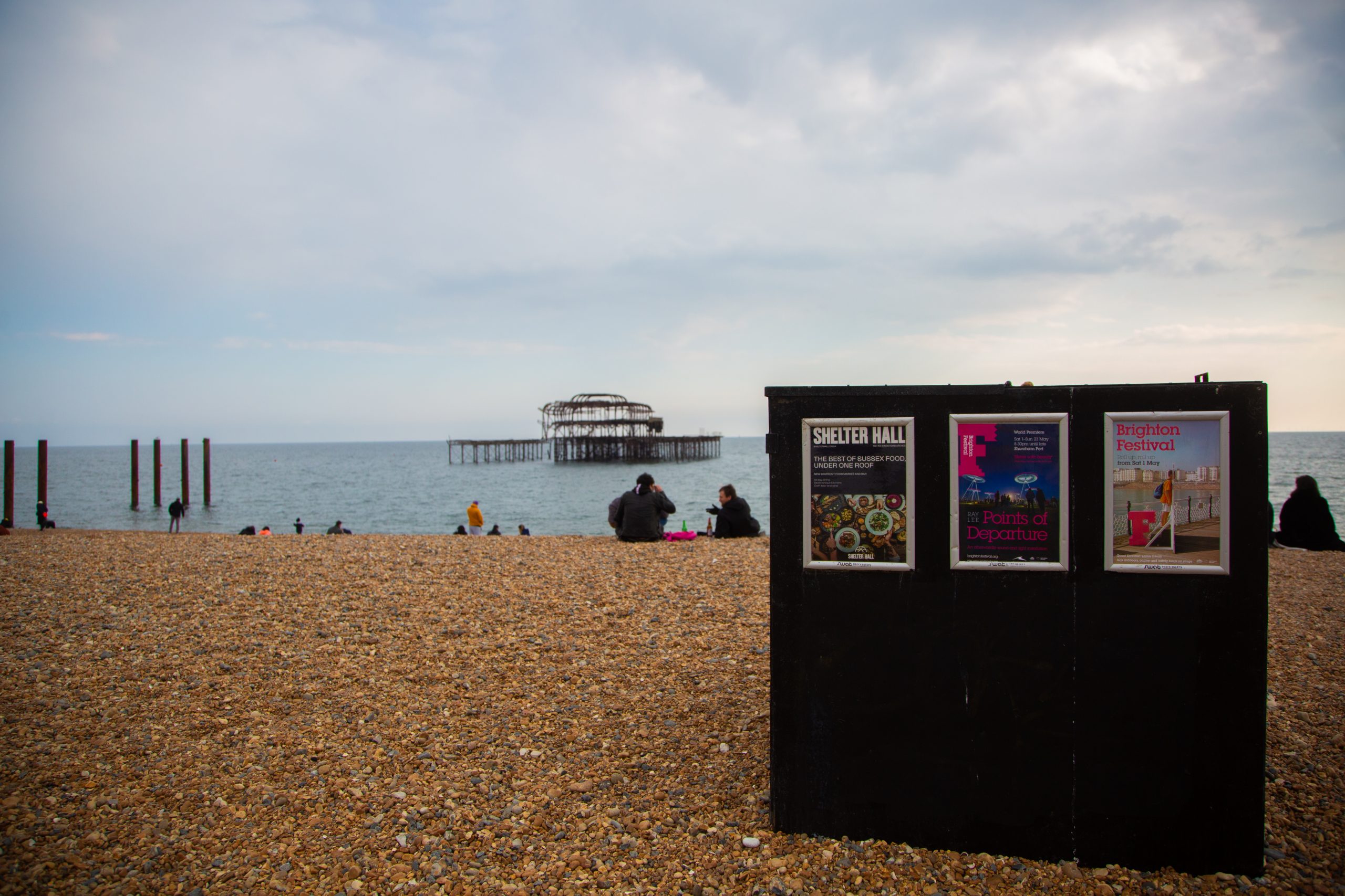 Black billboard on Brighton Beach with 3 posters attached
